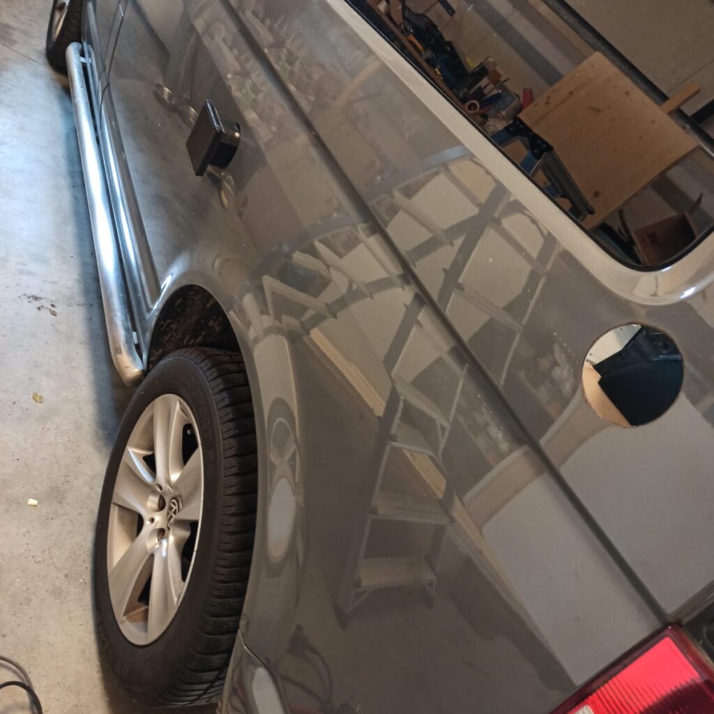 Buitenkant van de camper met de zojuist geplaatste aansluiting voor de stroompaal en een gat voor het straks kunnen vullen van de watertank