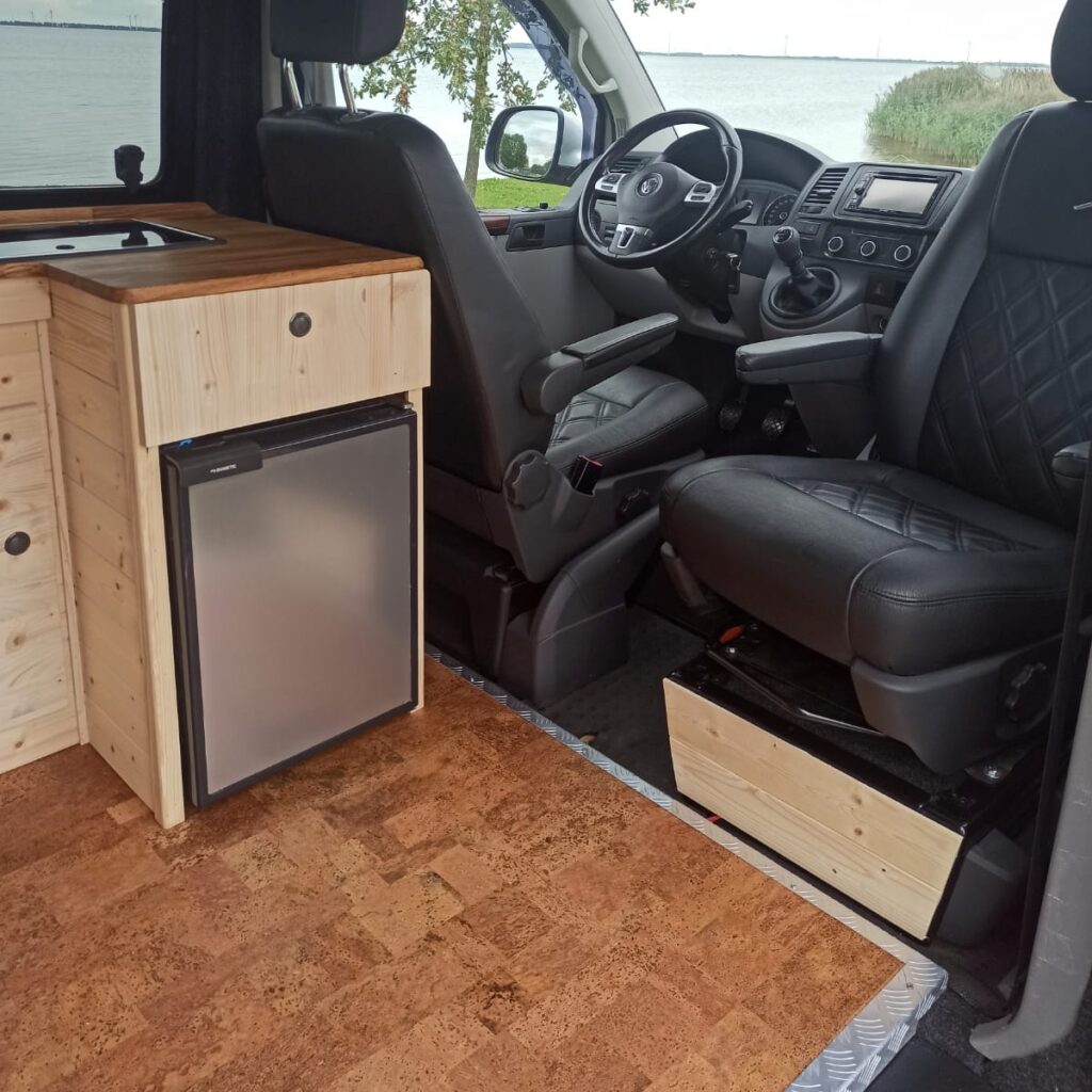 Voorstoelen met een deel van de keuken en de vloer van kurk (deze bus staat buiten en is een andere, maar wel met dezelfde inrichting als die van ons)